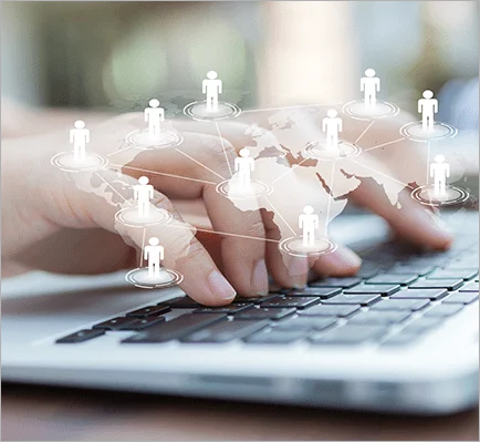 Immagine di mani su una tastiera del pc con in sovraimpressione una mondo con delle persone