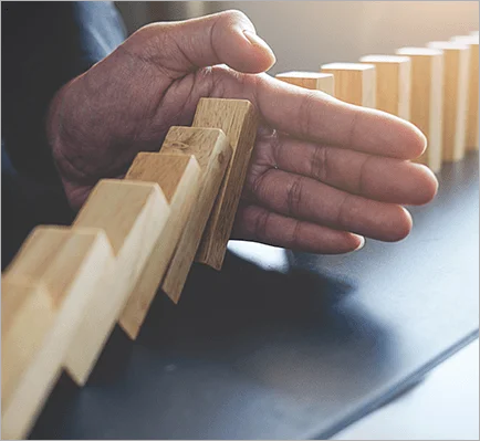 Immagine di un domino che viene stoppato da una mano